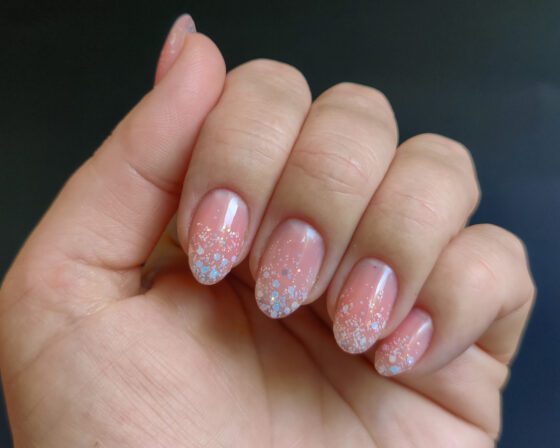 The same nails in shade, where the glitter fade reads as a soft white edge.