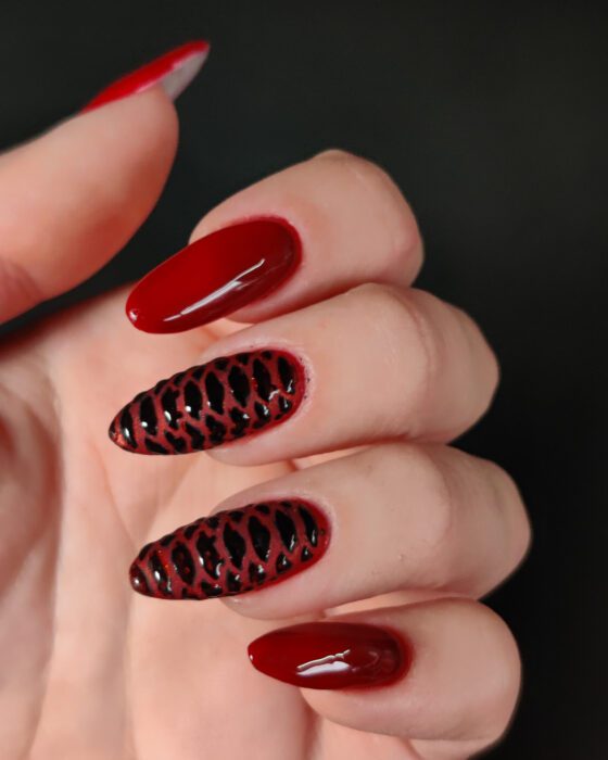 Close view of the red set against a dark background, showing the raised scales beside the plain glossy nails.