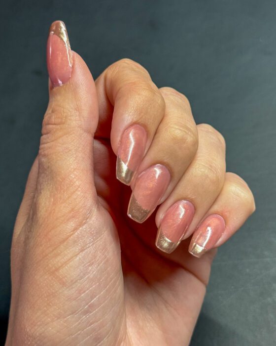 Close view of the gold chrome tips catching light, with the pearl pink base showing through.