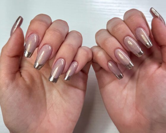 Long coffin extensions in sheer pearl with mirror silver chrome French tips, both hands facing the camera.