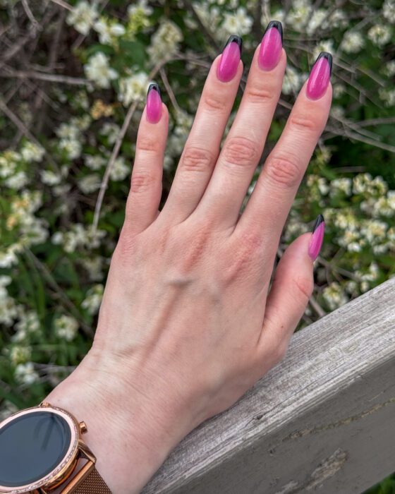 Side view of the pink and black set, the black tip visible on each nail.