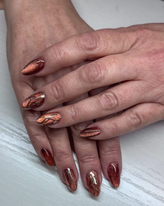 Angled view of the same autumn cat-eye set, the reflective copper bands and gold swirls visible together.