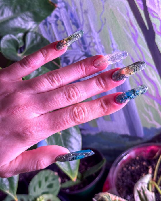 Extra-long oval extensions in turquoise, teal and clear sea tones with reflective flecks through the set.