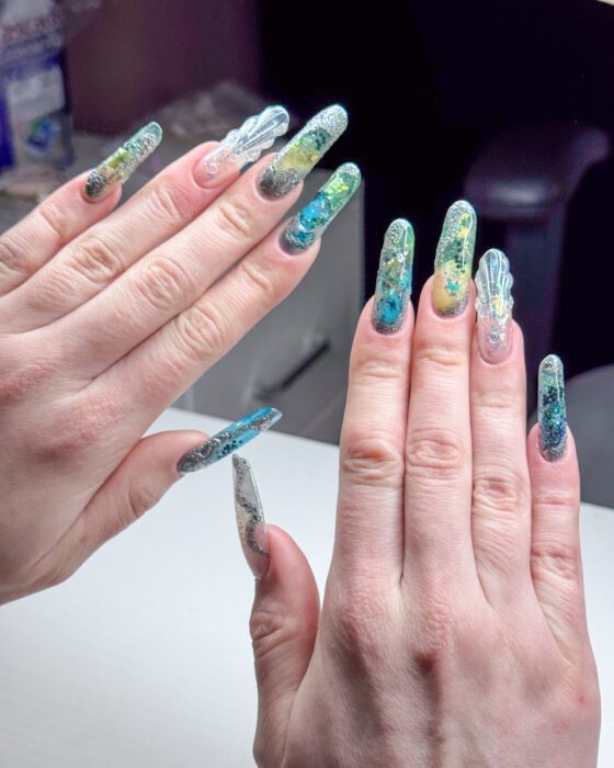 Silver and pale iridescent detail along the sea-toned extensions.