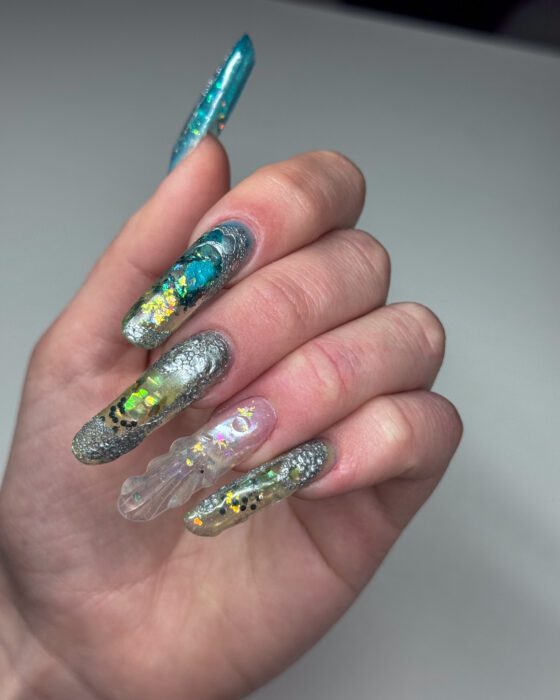 Layered clear and teal sections visible on the extra-long oval extensions.