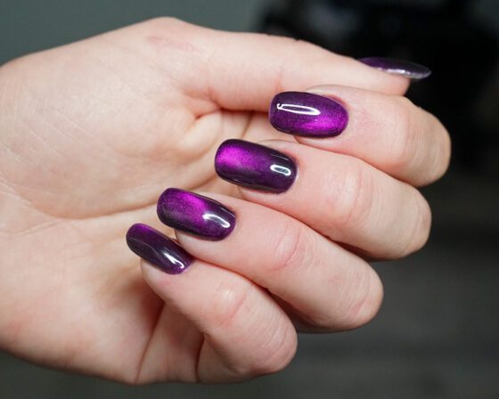 The purple hand curled, vivid magenta cat-eye reflection.