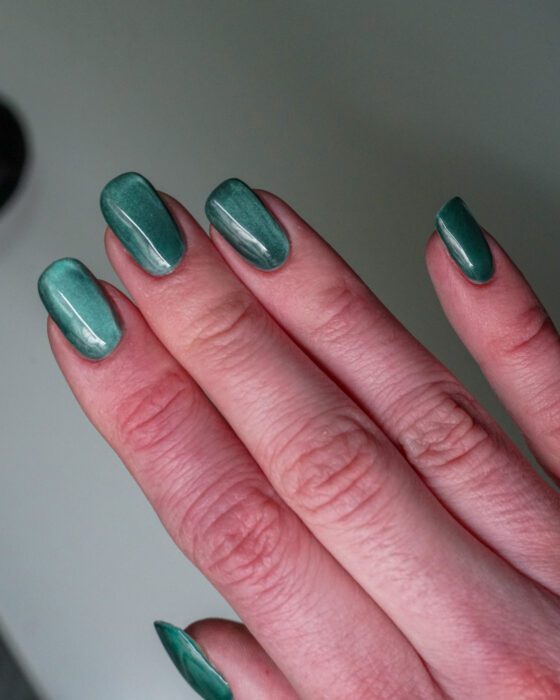 The green hand with reflective bands visible across every nail.