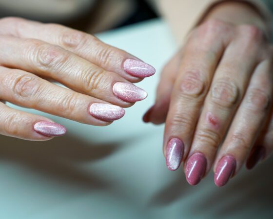 Both hands from above, the same pink cat-eye set at different angles.