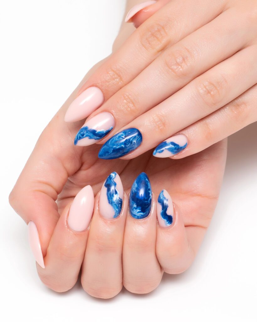 Almond nails in sheer pink with blue and white marbled ink accents