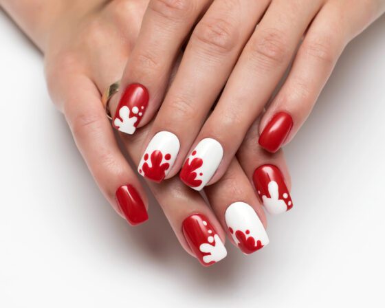 Short square nails in glossy red with white accent nails splashed with red drips